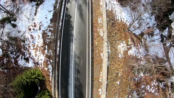 Drone Shot With A Road Through The Forest In A Sunny Winter Day