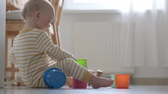 Little Baby Playing with Educational Colorful Toys at Home Sitting on Floor