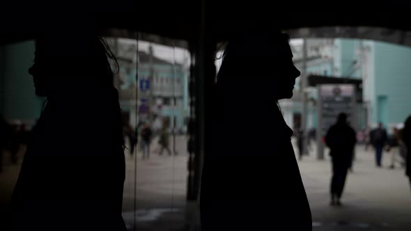 People are Walking on City Street Silhouette of Crying Woman in Dark Lane