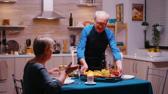 Elderly Senior Serving Dinner to His Wife