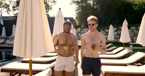 Smiling Male Friends Enjoying Cocktails Near Swimming Pool