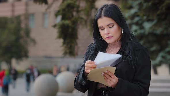 Stressed Worried Hispanic Businesswoman Student Reading Bad News in Mail Letter Outdoors Feeling