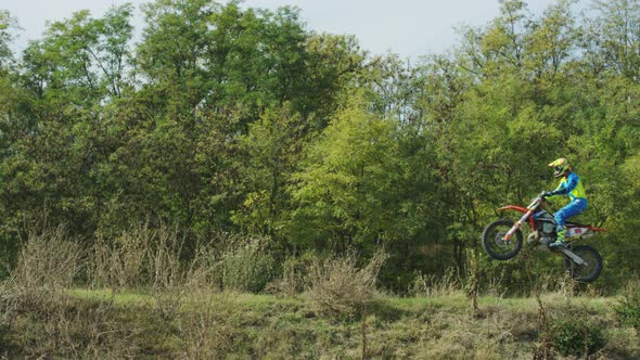 Motocross stunts near a forest