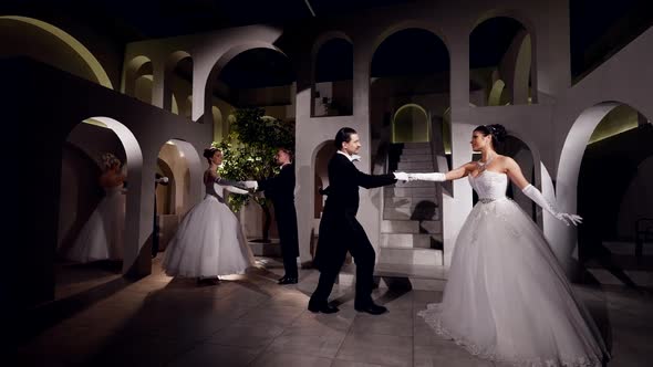 Couples Waltz in the Hall of an Ancient Castle in the Light of Spotlights