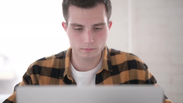 Close Up of Young Man Working on Laptop