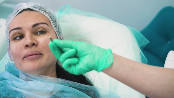 Cosmetologist Shows Needle for Filler Injection To Client