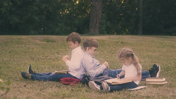 Young Concentrated Pupil Reads Book Sitting Near Small Lady