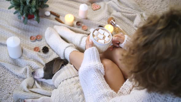 Female In Knit Sweater And Socks Holding Hot Cacao Cup At Home