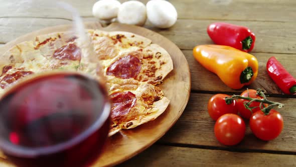 Delicious pizza with a glass of wine, vegetable and spices