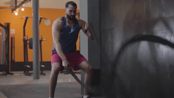 Strong Muscular Sportsman Doing Crossfit Exercise in Gym