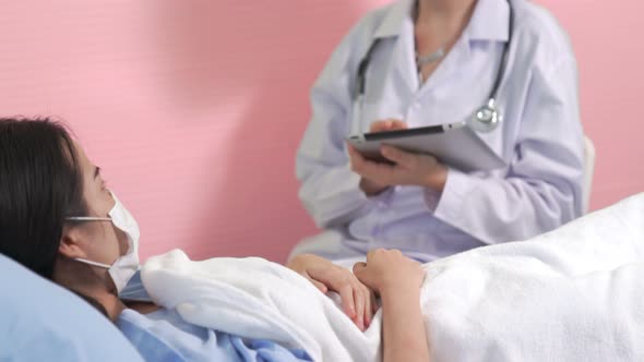 Doctor Wearing Face Mask Proficiently Talks with Patient at Hospital Ward