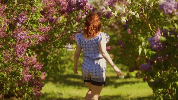 Happy and Smiling Woman Runs Around Lilac Field and Turns Around