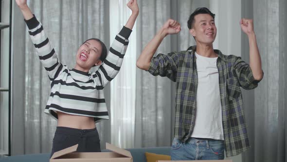 Happy Asian Couple Celebrating Finish Carrying Cardboard Boxes With Stuff Into A New House