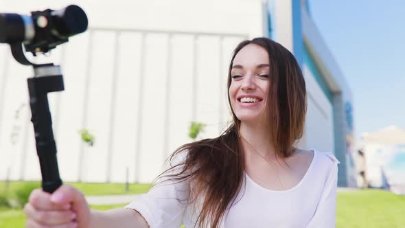 Video blogger. Woman filming vlog on camera at street