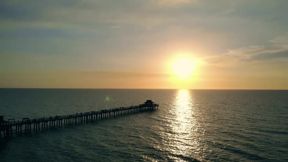 Dark Silhouette of a Pier Over the Water at Sunset