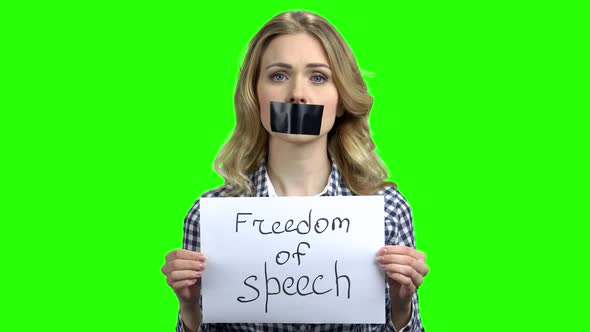 Young Woman with Taped Mouth on Green Screen