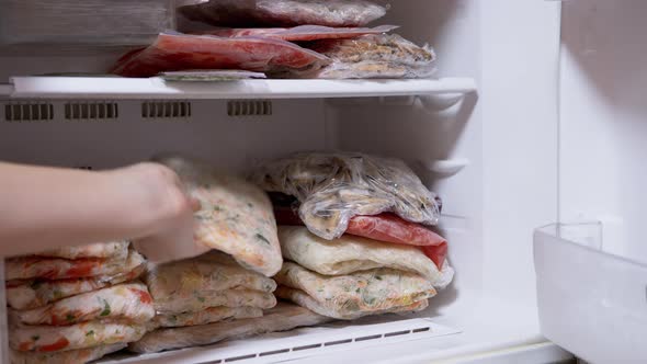 Female Hands Lay Out Frozen Vegetable Briquettes in Freezer