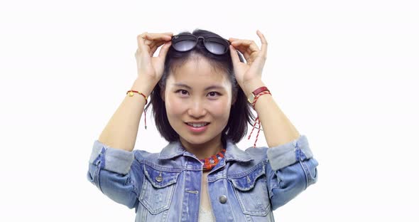 Beautiful Young Asian Chinese Adult Woman Happy Smiling Putting on Sunglasseswearing Casual