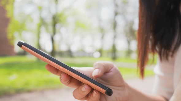 Close up hand and phone of Asian woman with black straight hair. Using smartphone