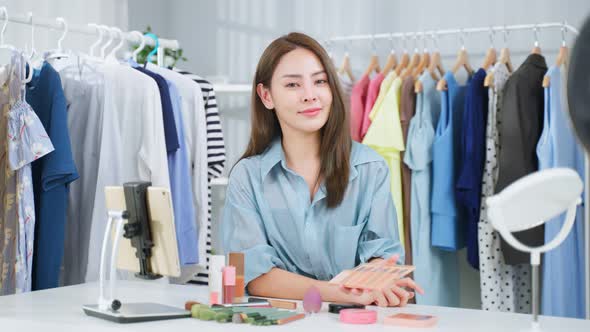 Portrait of Asian business woman vlogger review the cosmetic at home.