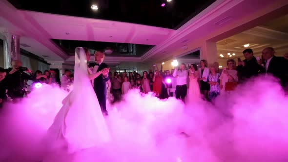 Beautiful Young Newlyweds Dancing Their First Dance Shrouded By White Fume