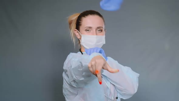 Pretty Lady in Medical Coat Throws Blue Sterile Glove