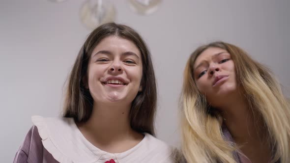 Child POV of Two Smiling Young Women Talking Admiring Newborn Indoors