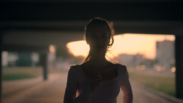 A Young Woman Runner is Training in the Summer Within a City