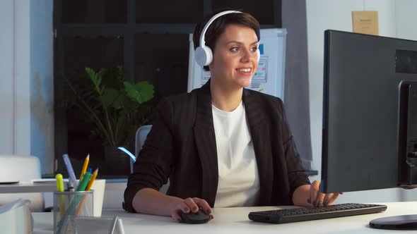 Businesswoman in Earphones with Computer at Office 64