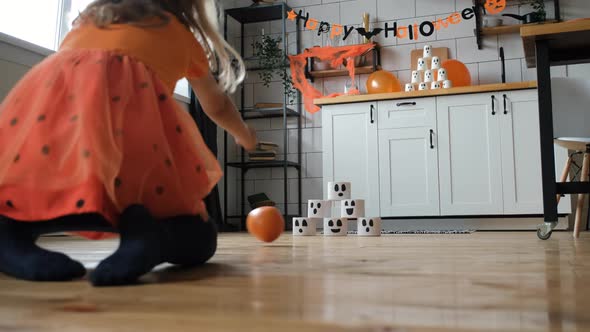 Little Girl Playing Pumpkin Bowl in Halloween