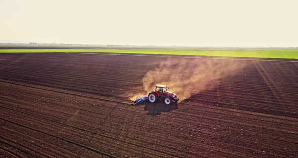 Farmer in tractor seeding corn on agricultural field