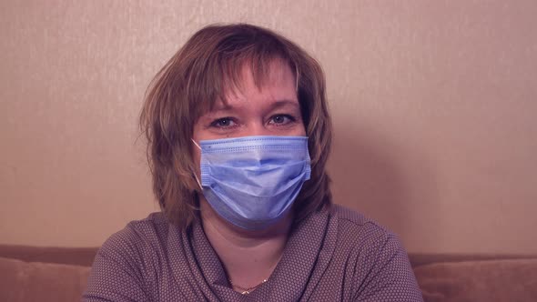 Happy Woman in a Medical Mask is Looking at the Camera and Talking