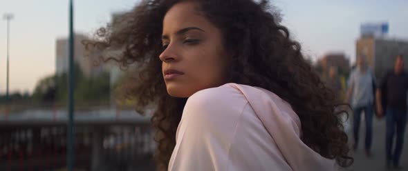 Handheld video of serious beautiful Brazilian woman outside. Shot with RED helium camera in 8K.