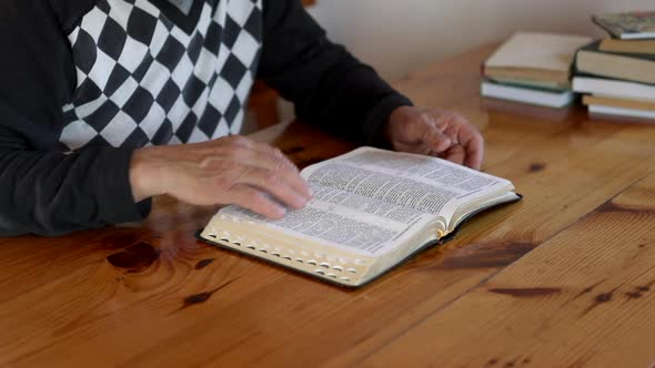 Senior Man Praying Reading an Old Bible in His Hands