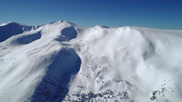 Flight Over the Turquoise Snowy Mountains Illuminated By the Day Sun