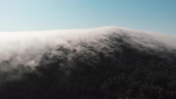 aerial moves to an amazing lenticular cloud formation blanketing the mountain of Monte de Santa Tecl