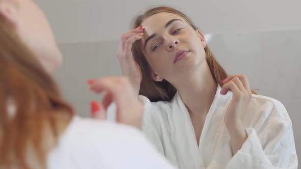 Close-up Beauty Portrait of Young Woman with Smooth Healthy Skin, She Gently Touches Her Face with