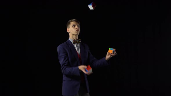 Handsome Male in Suit Is Juggling Rubik's Cube in Dark.