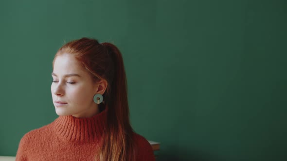 Portrait of Beautiful Redhead Lady on Green Wall