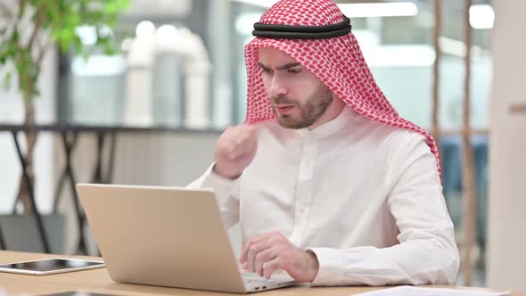 Sick Arab Businessman with Laptop Coughing in Office