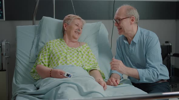 Mother and Child Visiting Sick Grandma in Hospital Ward Bed