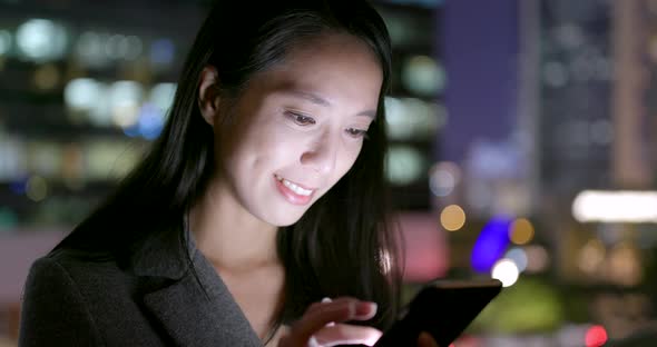 Woman use of smart phone at outdoor in the evening