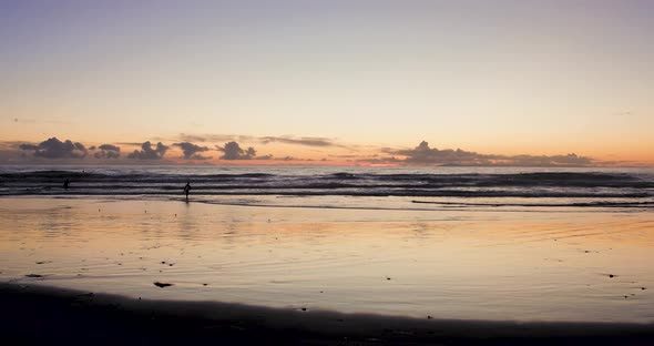 A camera is set up on a tripod to take pictures of the stunning view of the sunset at low tide in La