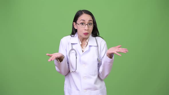 Young Beautiful Asian Woman Doctor Shrugging Shoulders