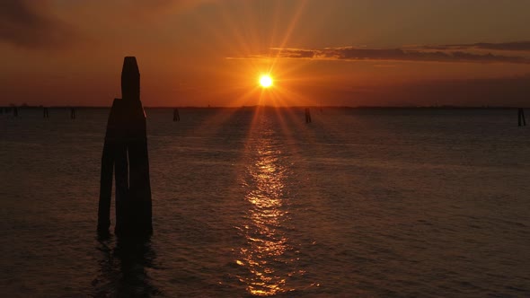 Pillar Silhouettes in Dark Sea with Rippling Water at Sunset