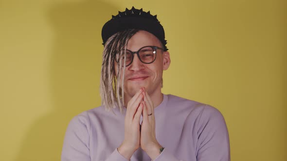 Young Handsome Man in Black Cap Glasses Pleading Looking at Camera