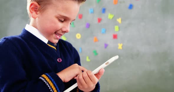 Schoolboy using digital tablet in classroom