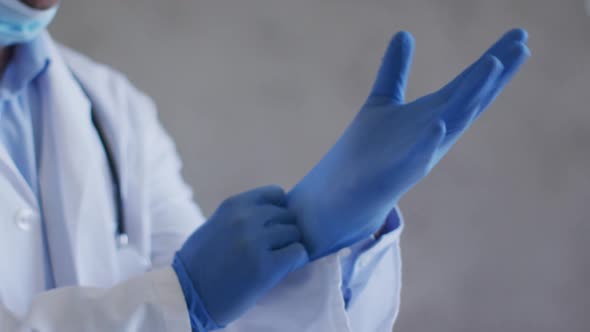 Caucasian male doctor wearing medical gloves and face mask