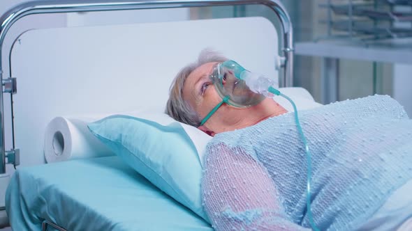 Retired Old Woman Breathing with Oxygen Mask