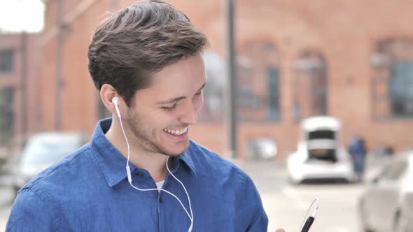 Outdoor Dancing Young Man Listening Music on Smartphone